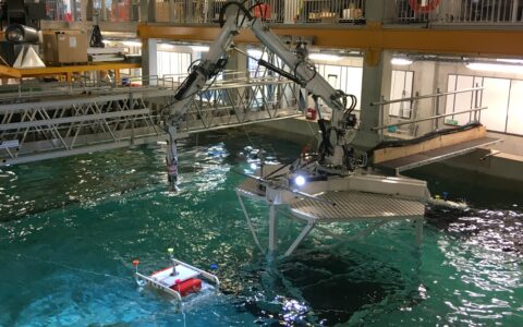 Photograph of Proteus 100 and model ROV in wave tank during testing.