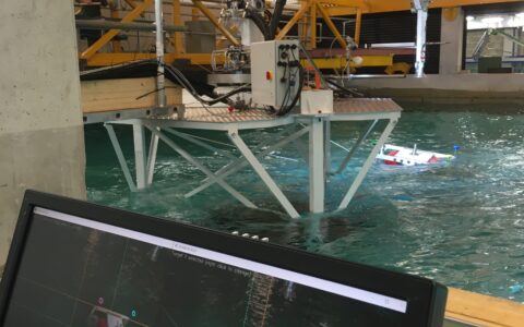 Photograph showing the operator screen and view of Proteus 100 during wave tank trials.